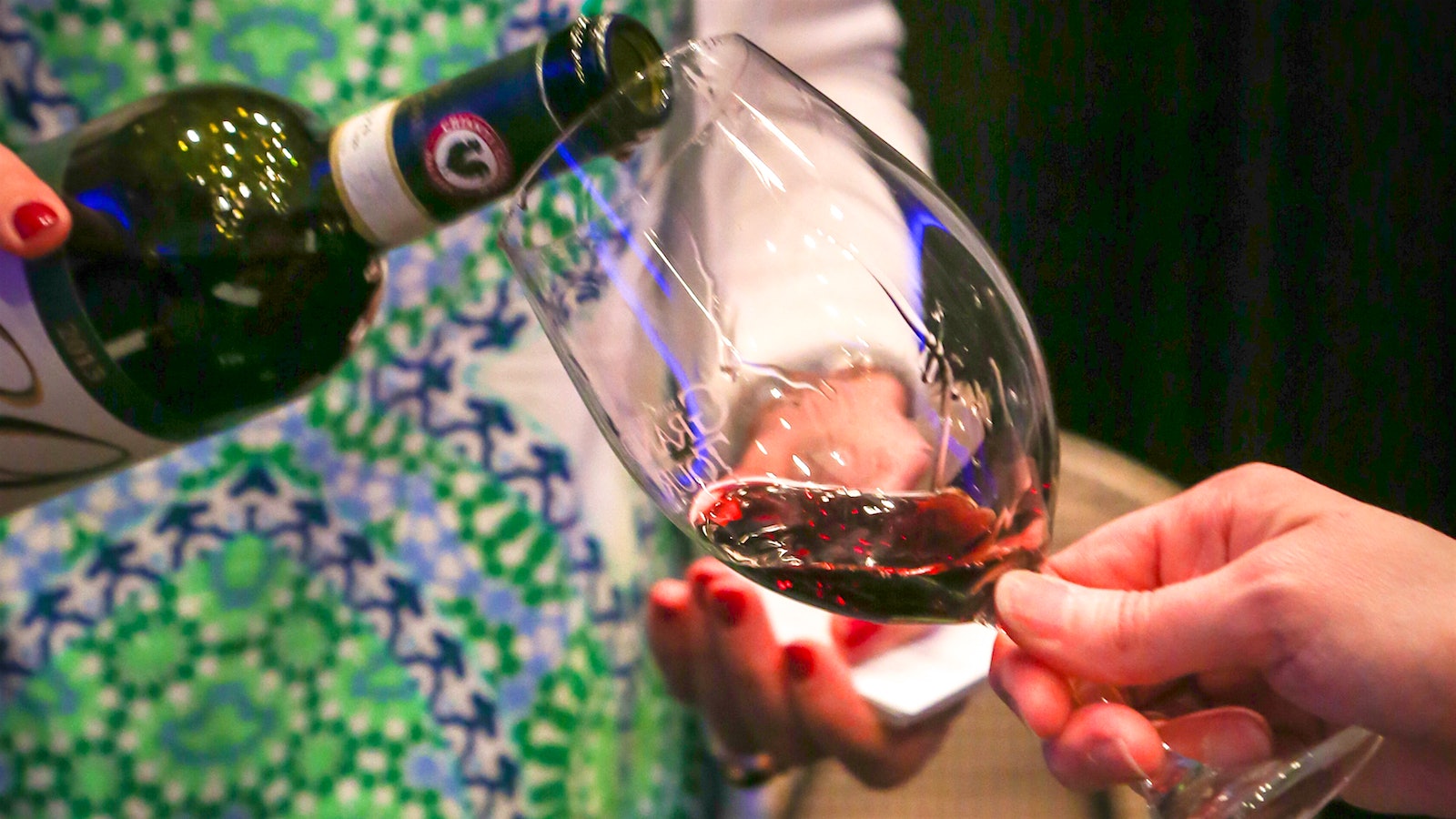 A woman pouring a glass of Chianti Classico for a guest at the 2019 Grand Tour in Miami